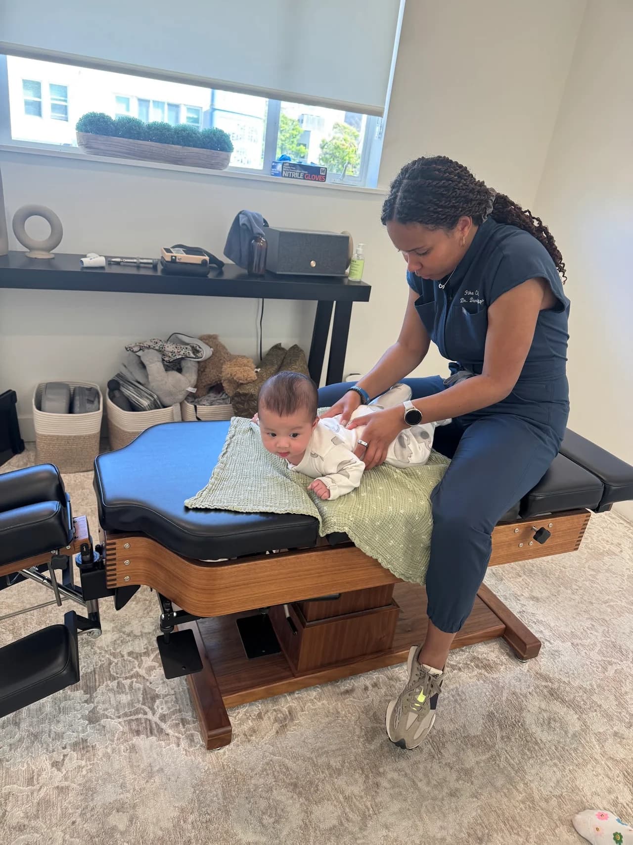 Gentle infant adjustment on the chiropractic table at Fika